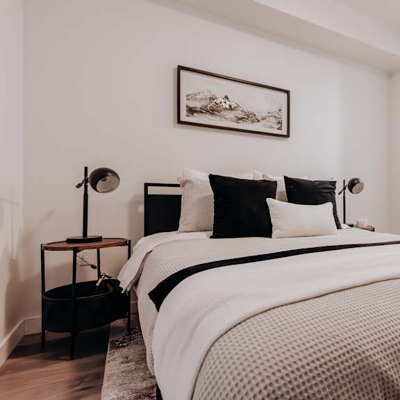 a bedroom with a large bed and a painting on the wall.
