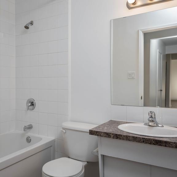 a white bathroom with a sink, toilet, and bathtub.