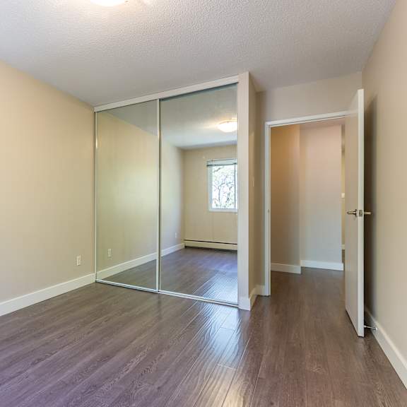 a room with a sliding glass door and wood flooring.