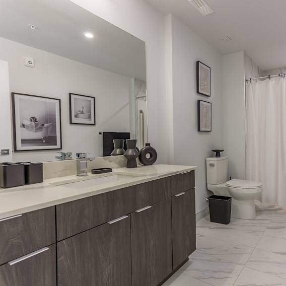 a bathroom with a toilet, sink, and shower.
