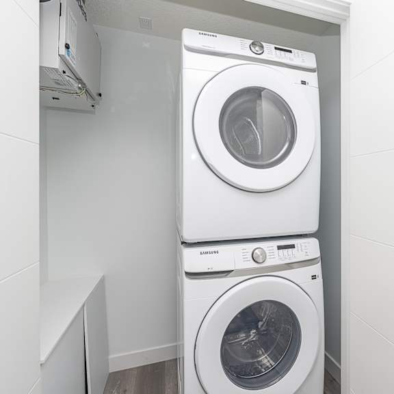 two samsung front loading washing machines in a small laundry room.