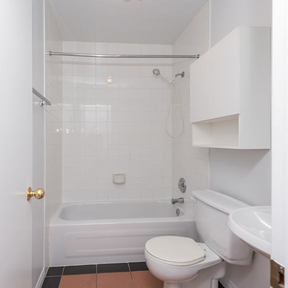 a white toilet is in a bathroom with a white tub and sink.