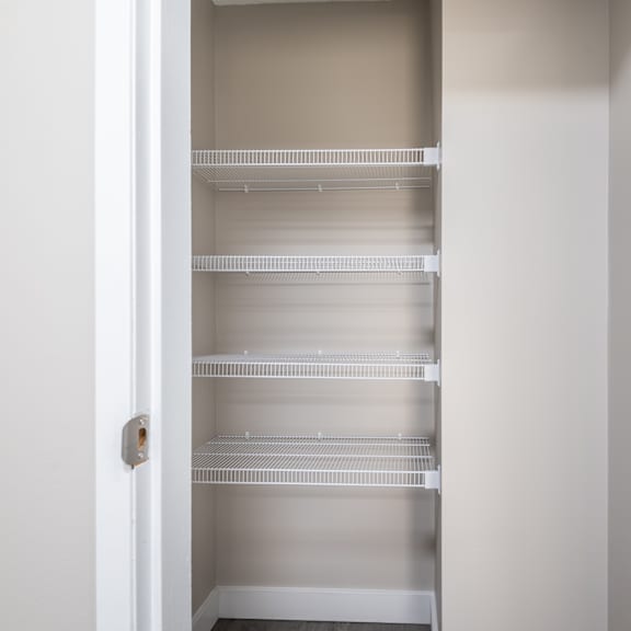 a white open pantry with empty shelves.