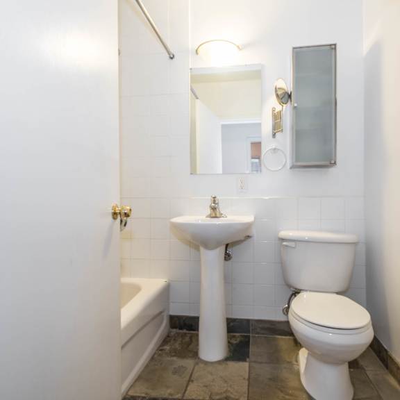 a white toilet sits next to a sink in a bathroom.