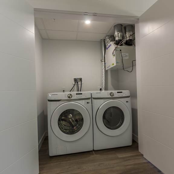 two front loading washing machines in a small laundry room.