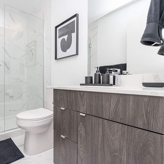 a bathroom with a toilet, sink, and a glass shower stall.