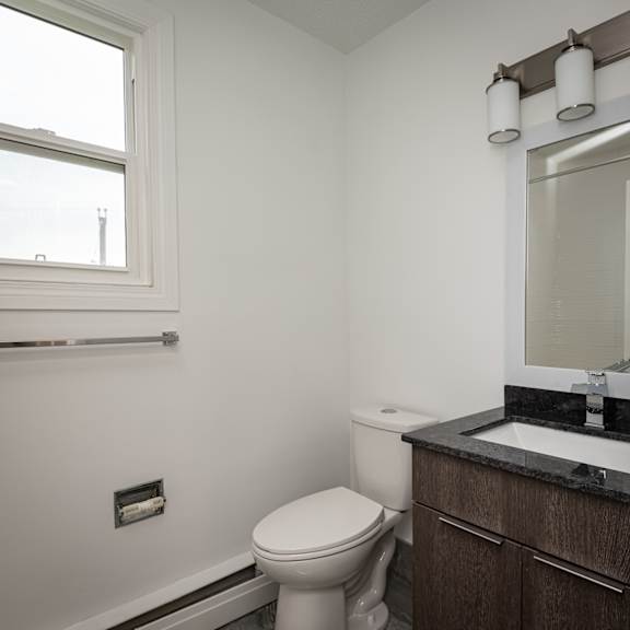 a white toilet sits next to a sink in a bathroom.