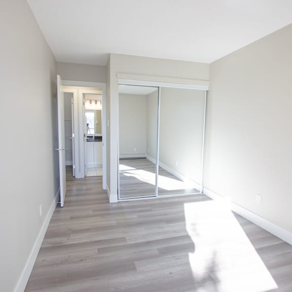 a hallway with a sliding glass door leading to a bedroom.