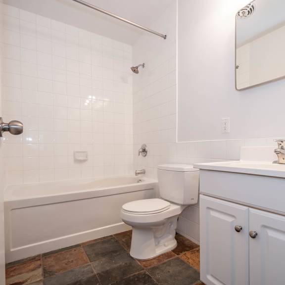 a white toilet sits in a bathroom next to a bathtub and a sink.