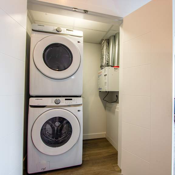 a white washing machine and dryer stacked on top of each other in a laundry room.
