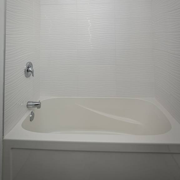 a white bathtub with a shower head and faucet.