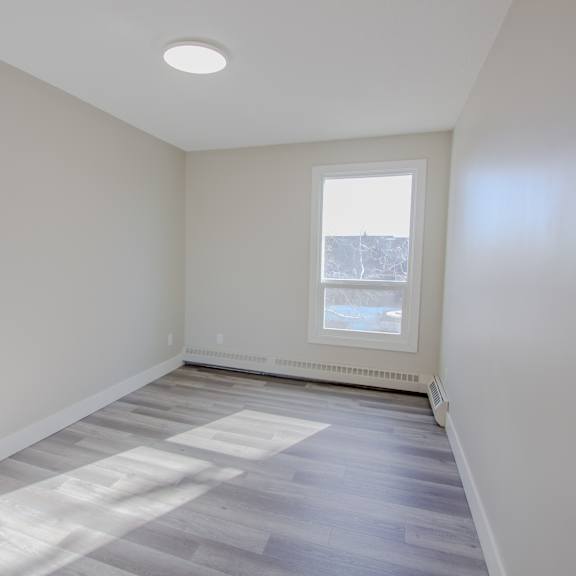 a room with a window and a radiator on the wall.
