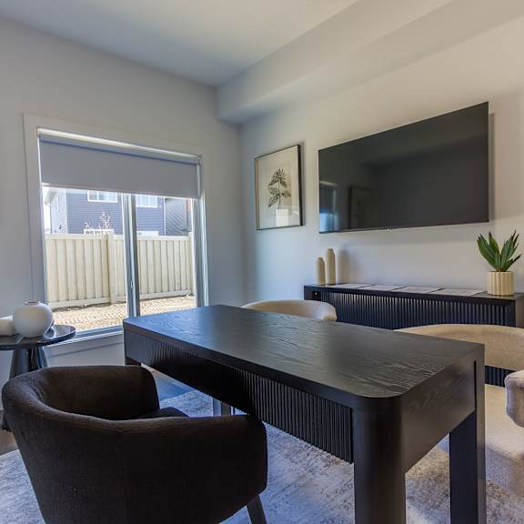 a modern dining room with a dark wood table and chairs.