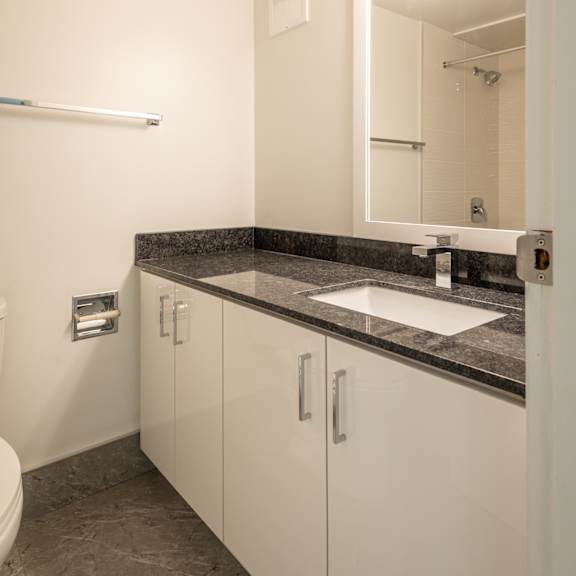 a bathroom with a sink, toilet and mirror.