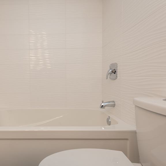 a white bathroom with a bathtub, toilet, and sink.