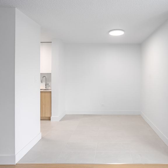 a white room with a wooden cabinet and a light on the ceiling.