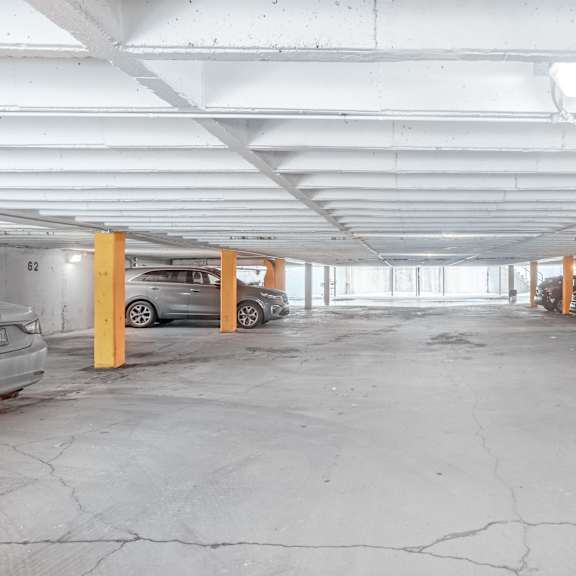 a parking garage with cars parked on the left and right side.