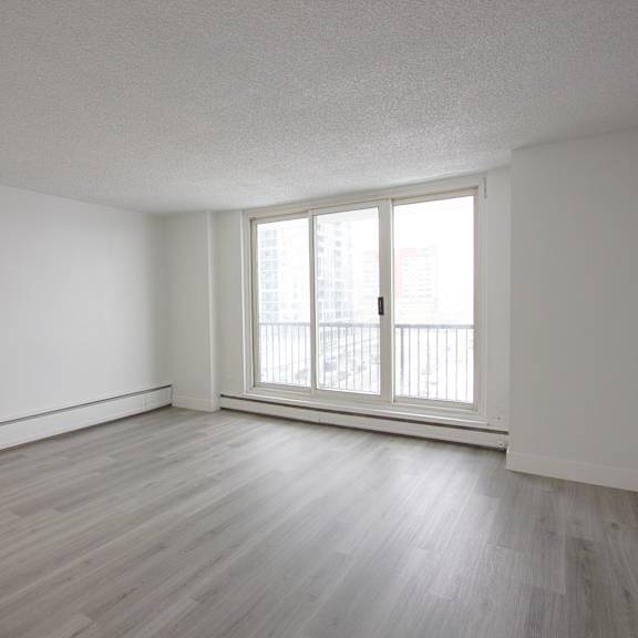 a room with a window and wooden flooring.