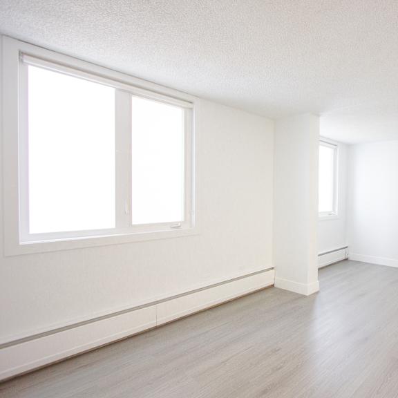 a room with a window and wooden flooring.