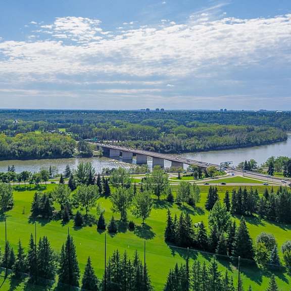 a bridge spans a river in a lush green landscape.
