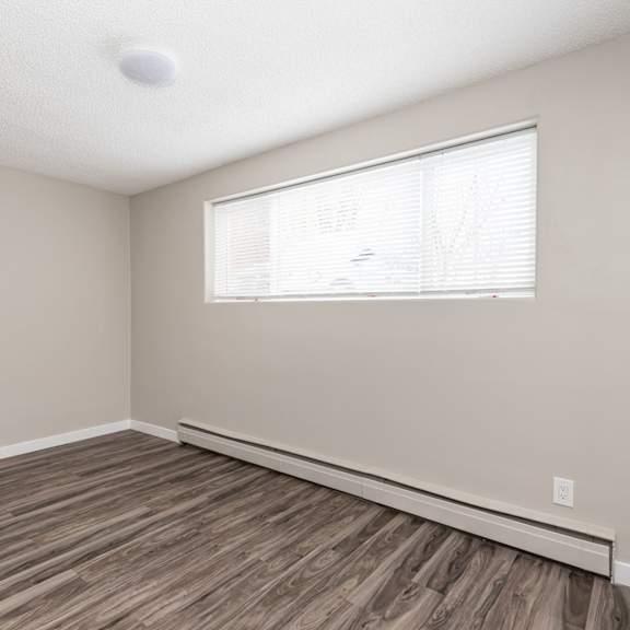 a room with a window and wooden flooring.