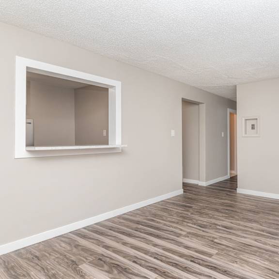 a room with wooden flooring and a window on the left side.