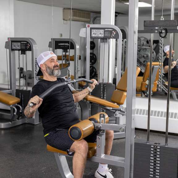 a man is working out in a gym using a machine.