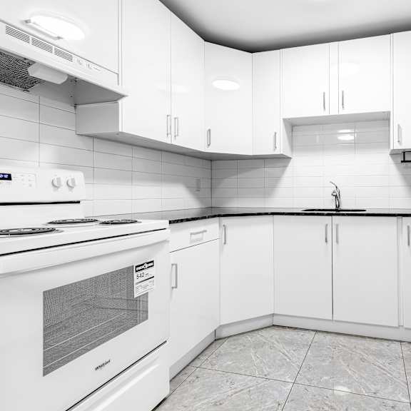 a white kitchen with a tile floor and white cabinets.