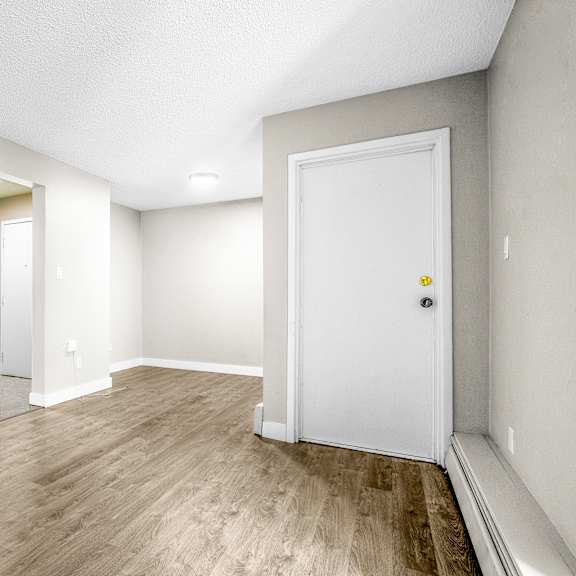 a room with a white door and a mirror on the wall.