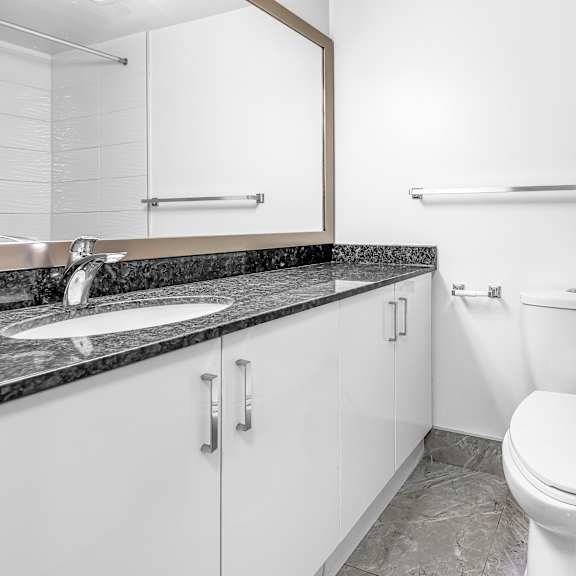 a white toilet sits next to a sink in a bathroom.