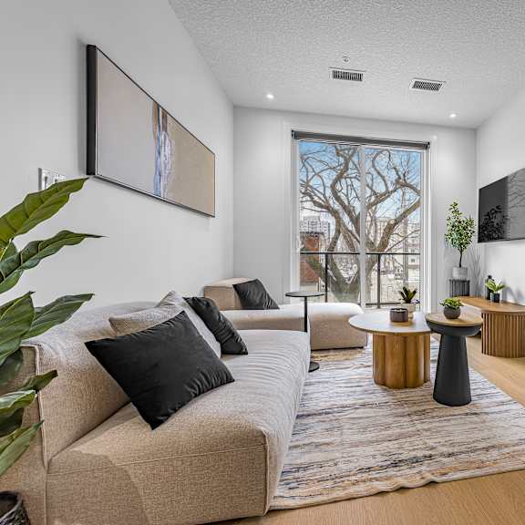 a living room with a beige couch and a large window.