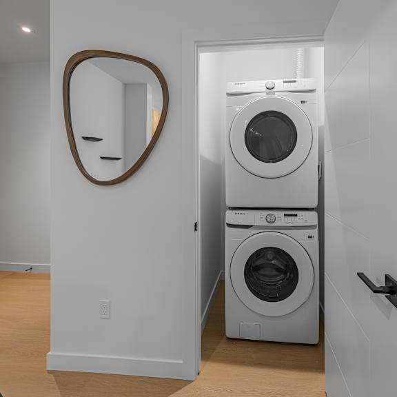 a laundry room with a washer and dryer stacked on top of each other.