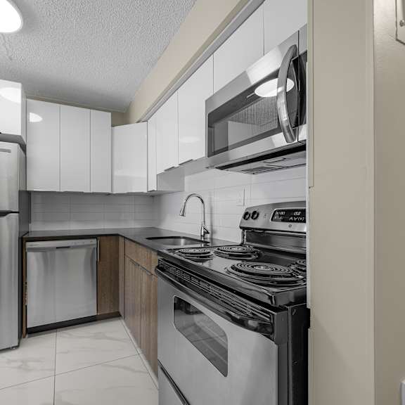 a modern kitchen with stainless steel appliances and white cabinets.
