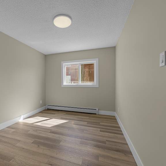 a room with wooden flooring and a window.