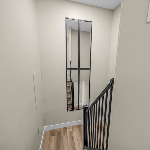 a mirror on the wall above a staircase.