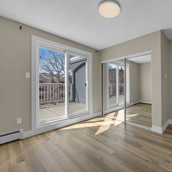 a room with a sliding glass door leading to a balcony.