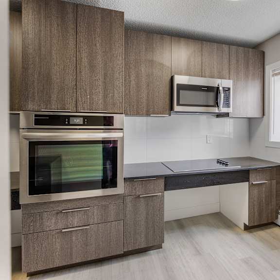 a modern kitchen with wooden cabinets and a black countertop.