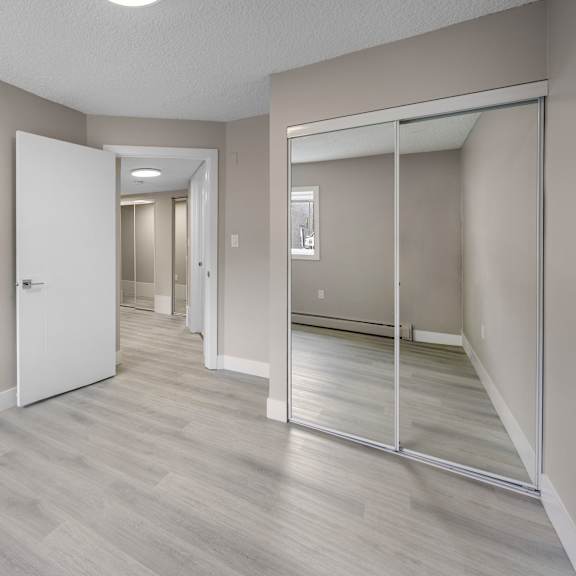 a room with a white door and a mirror on the wall.