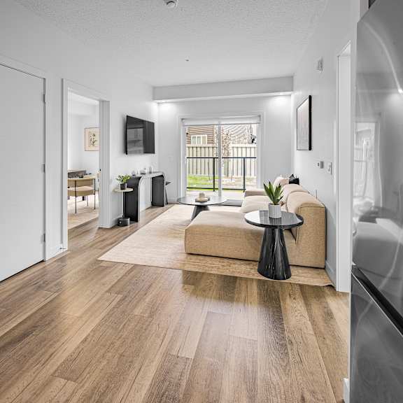 a modern living room with a wooden floor and a large window.