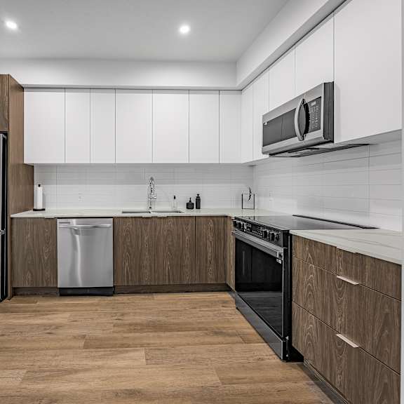 a modern kitchen with wooden cabinets and stainless steel appliances.