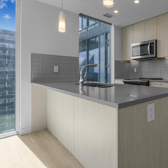 a modern kitchen with a refrigerator, microwave, and stove.