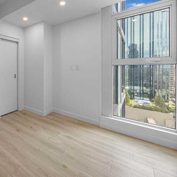a room with a large window and wooden flooring.