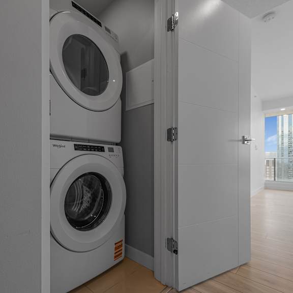 a modern laundry room with a washer and dryer built into the wall.