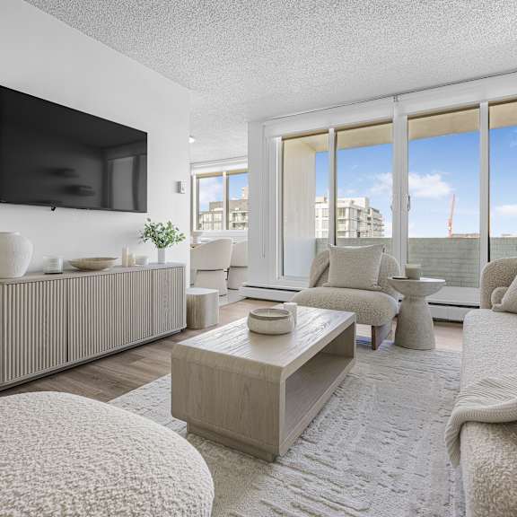 a living room with a television, sofas, and a coffee table.