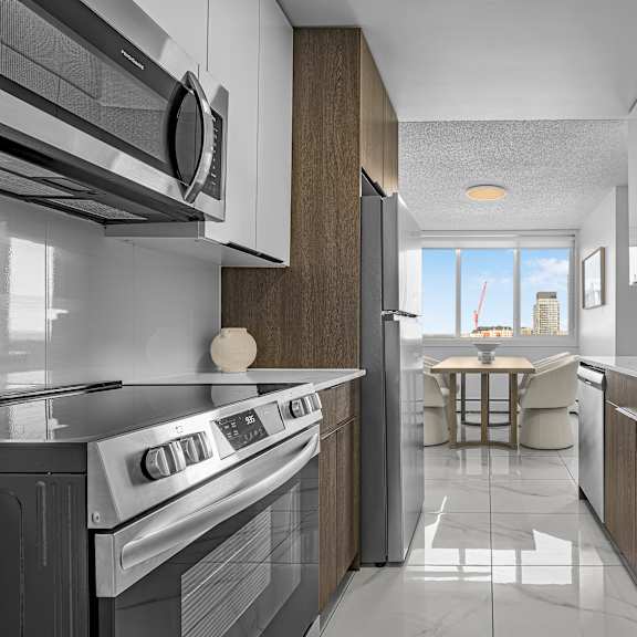 a modern kitchen with a stainless steel oven and white cabinets.