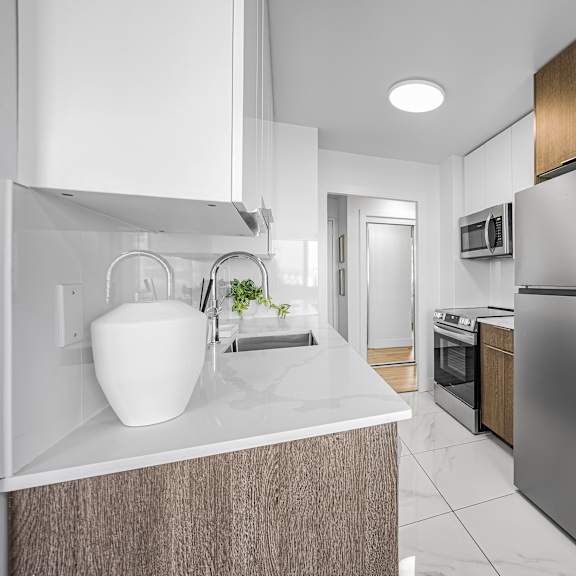 a modern kitchen with a stainless steel refrigerator and wooden cabinets.