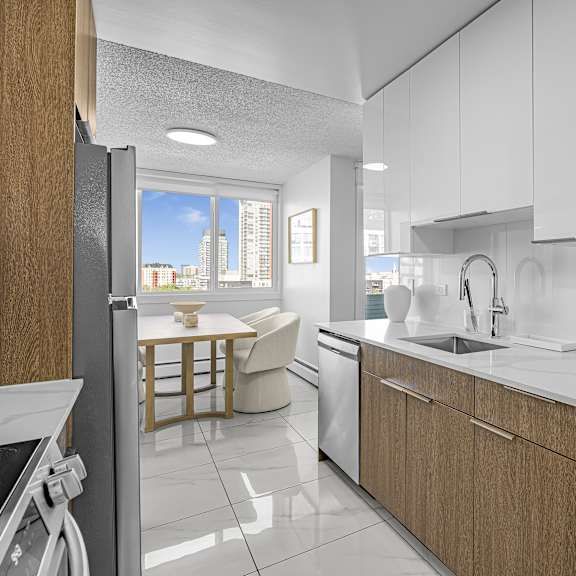 a modern kitchen with white cabinets and a wooden island.