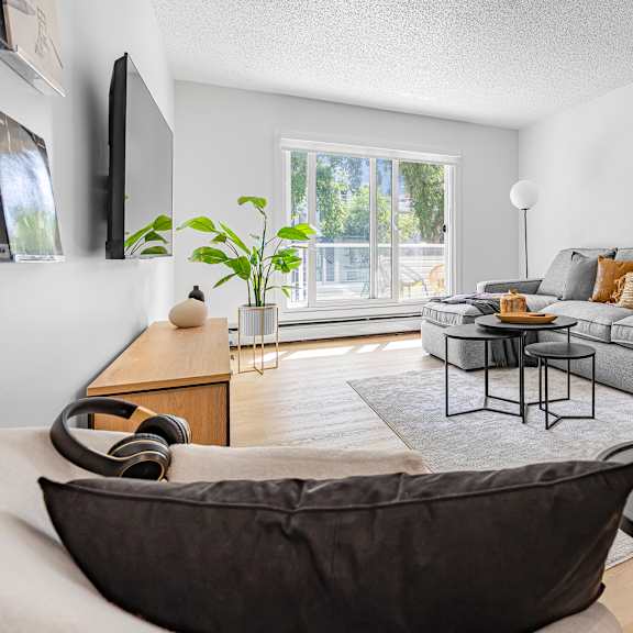 a living room with a grey couch, a black armchair, and a coffee table.
