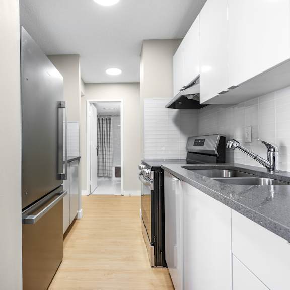 a modern kitchen with white cabinets and a black countertop.
