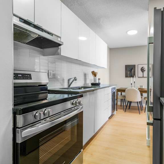 a modern kitchen with a black refrigerator and stove top oven.